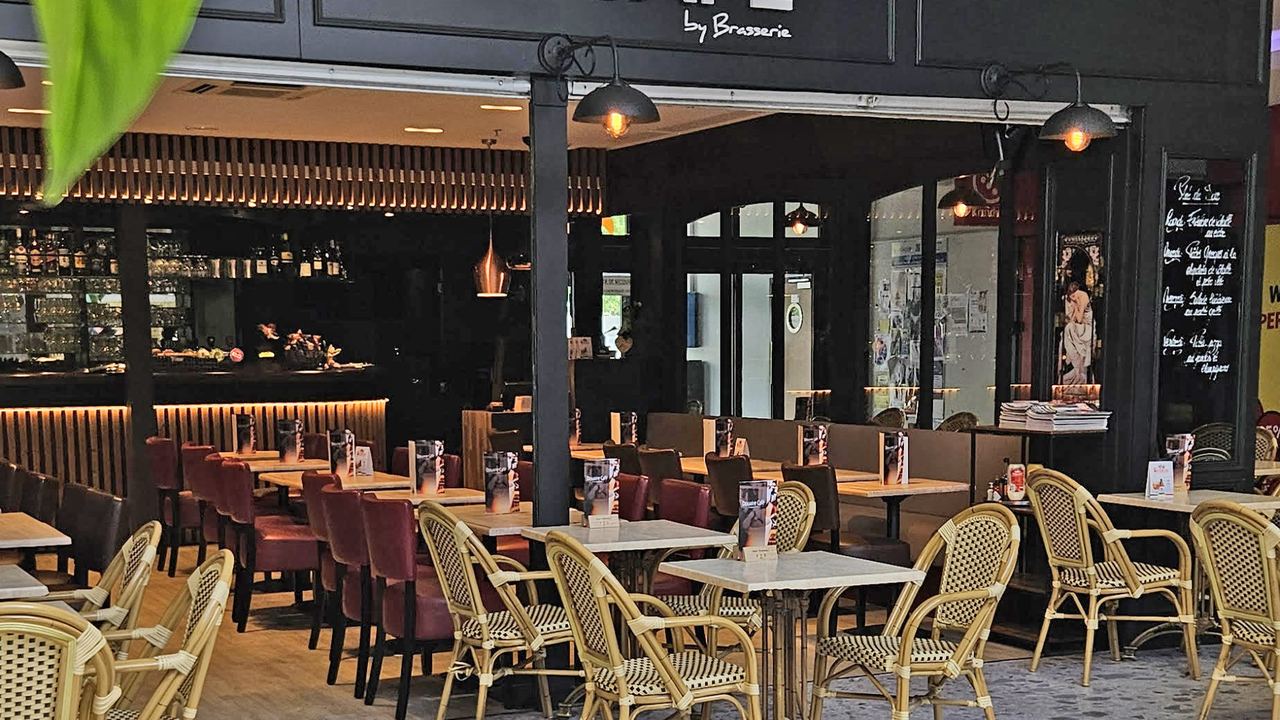Salle et terrasse du Douaire Café, tables en rotin dans la galerie du Douaire